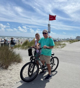 Monitor Most Influential Profile: Tina Guida | 2026 Operational Optimizers 4 Guida Tina bike riding at the beach